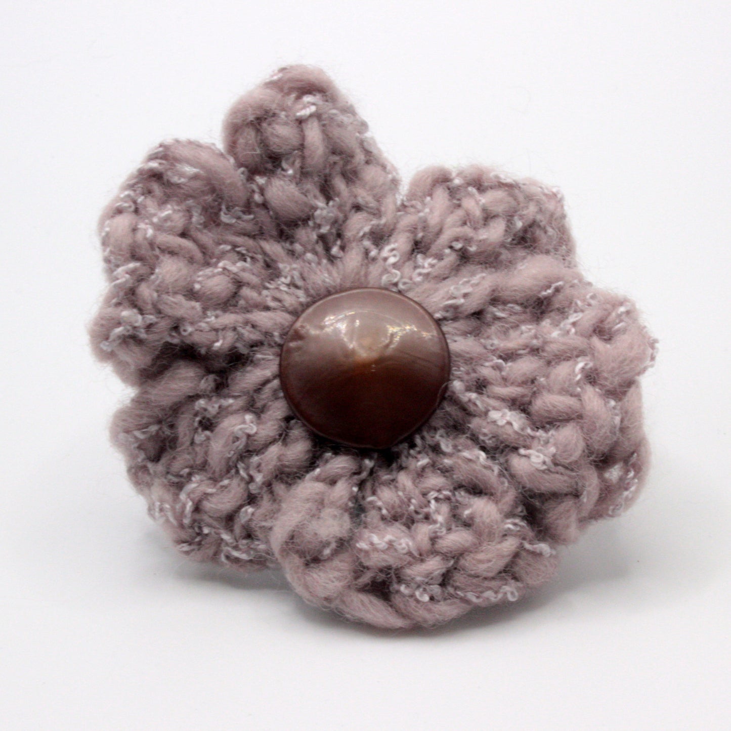 Knitted flower with a button center on a white background