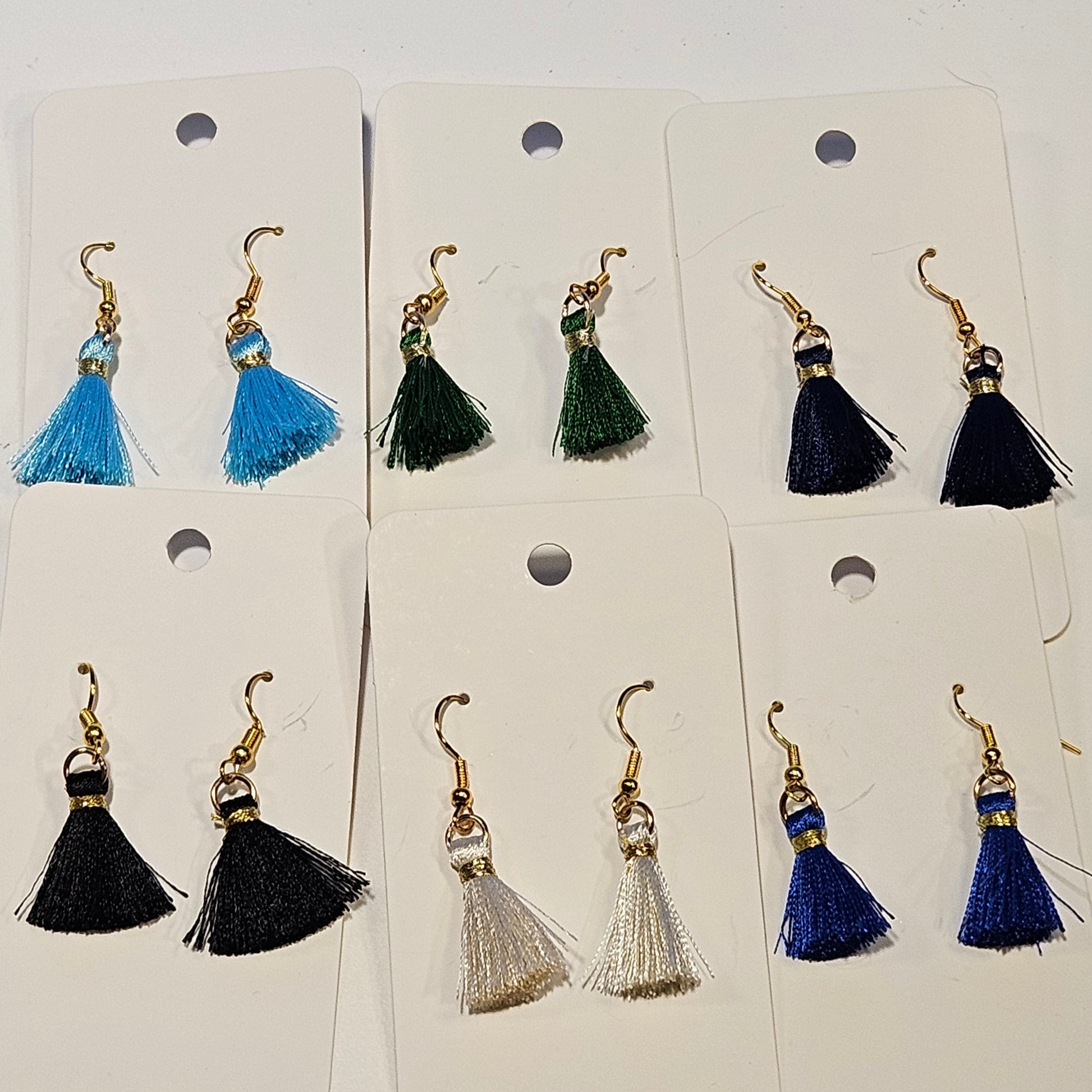 Set of tassel earrings on white cards with a plain background