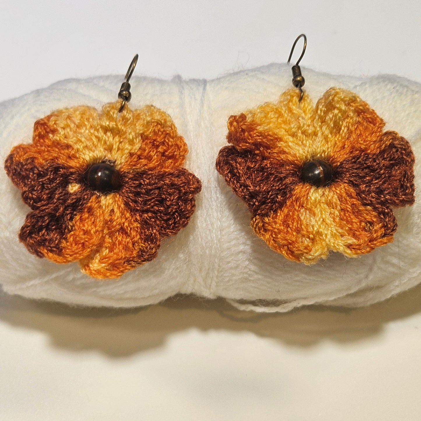 Pair of crocheted flower earrings on a white surface