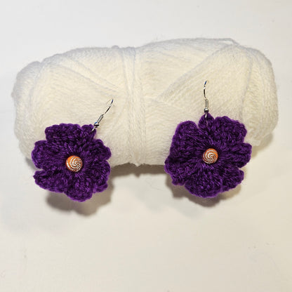 Purple crocheted flower earrings with gold centers on a white background