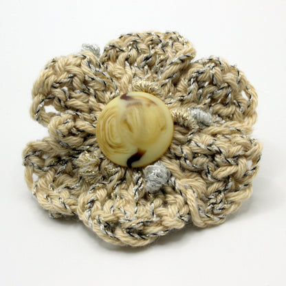 Crocheted flower with a button center on a white background