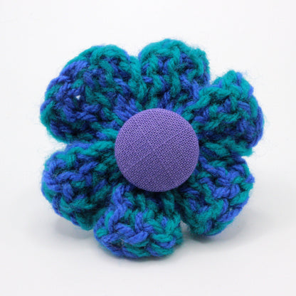 Crocheted flower with a purple center on a white background