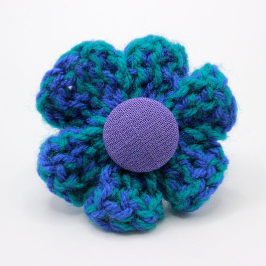 Crocheted flower with a purple center on a white background