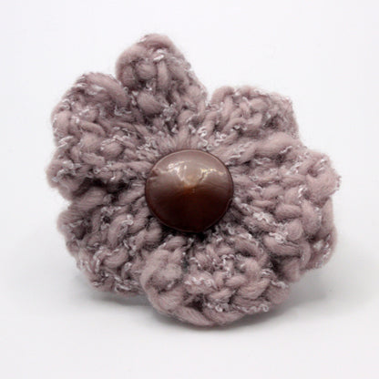 Knitted flower with a button center on a white background